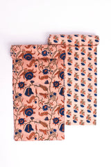 Two pieces of fabric with floral patterns, one featuring a larger floral design on a peach background and the other with a smaller floral design on a darker background.
