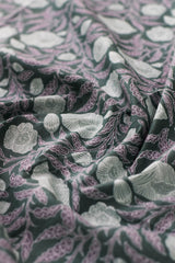 Close-up of floral patterned fabric in green, purple, and white.