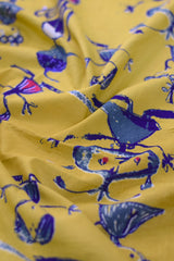 Close-up of yellow fabric with blue and red designs.