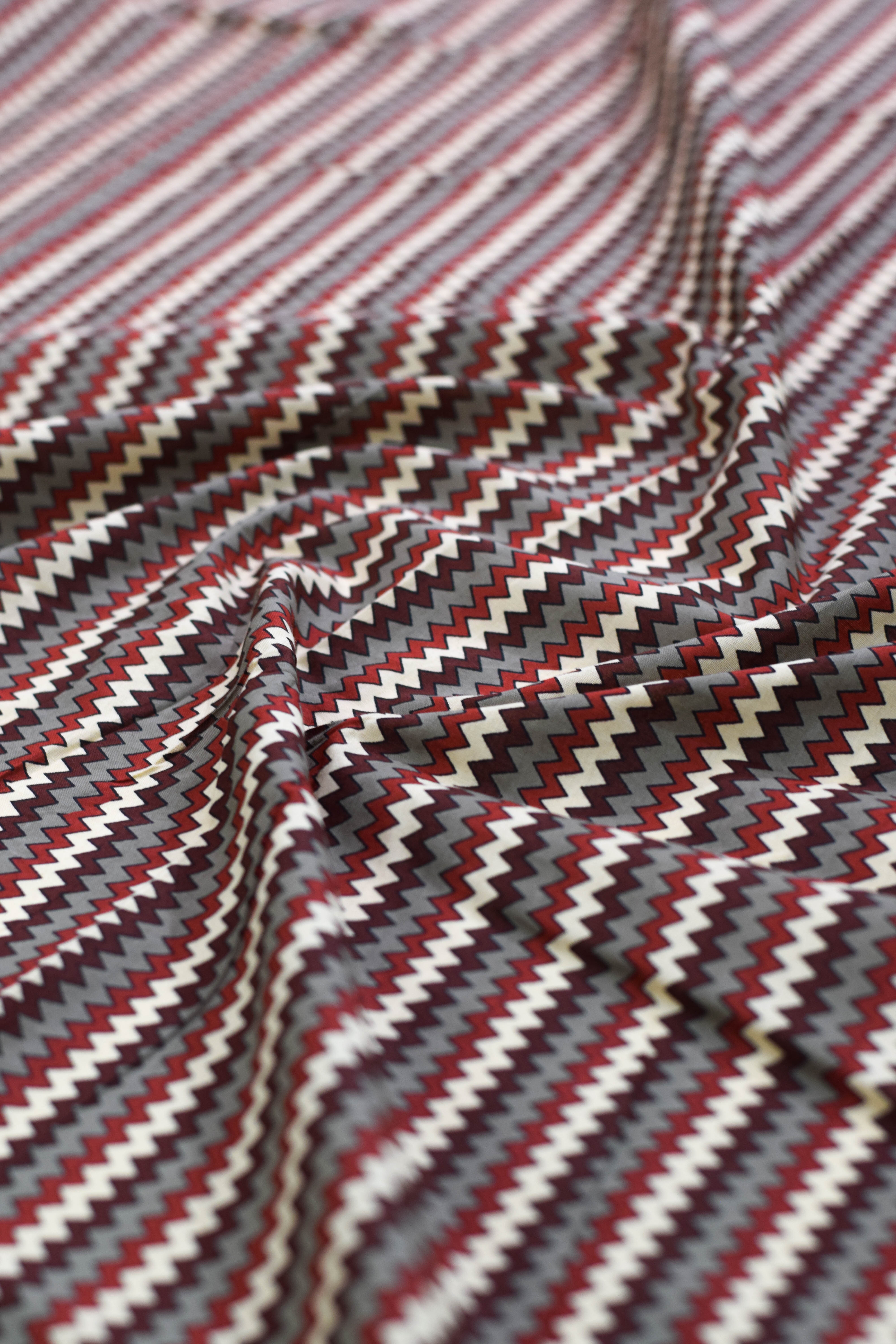 Close-up of zigzag patterned fabric in red, white, and gray.