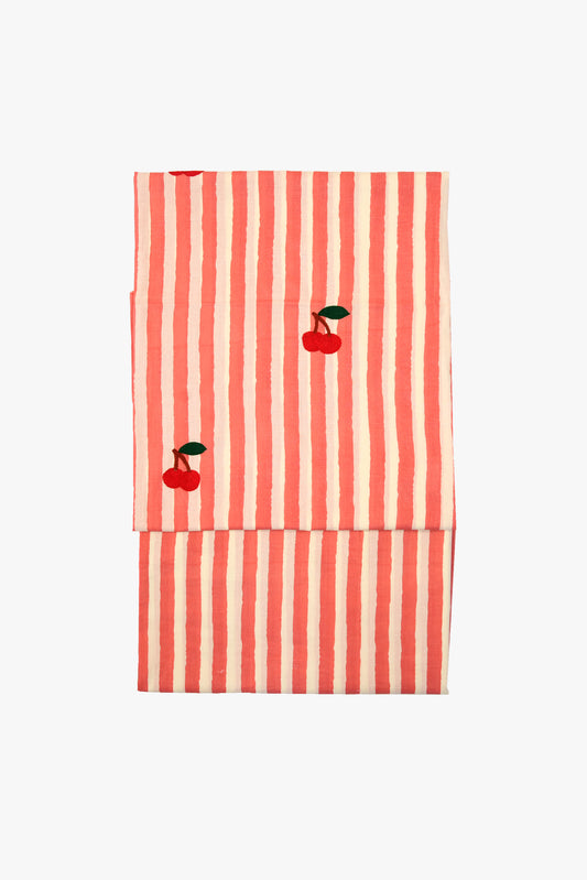 Red and white striped towel with cherry designs on a white background