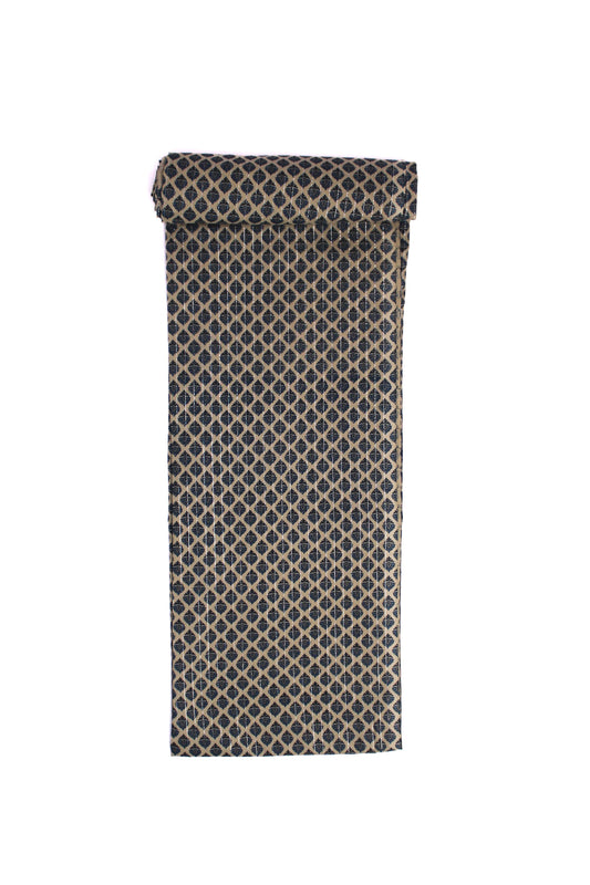 A swatch of fabric featuring a repeating indigo block-printed booti pattern on a beige canvas.
