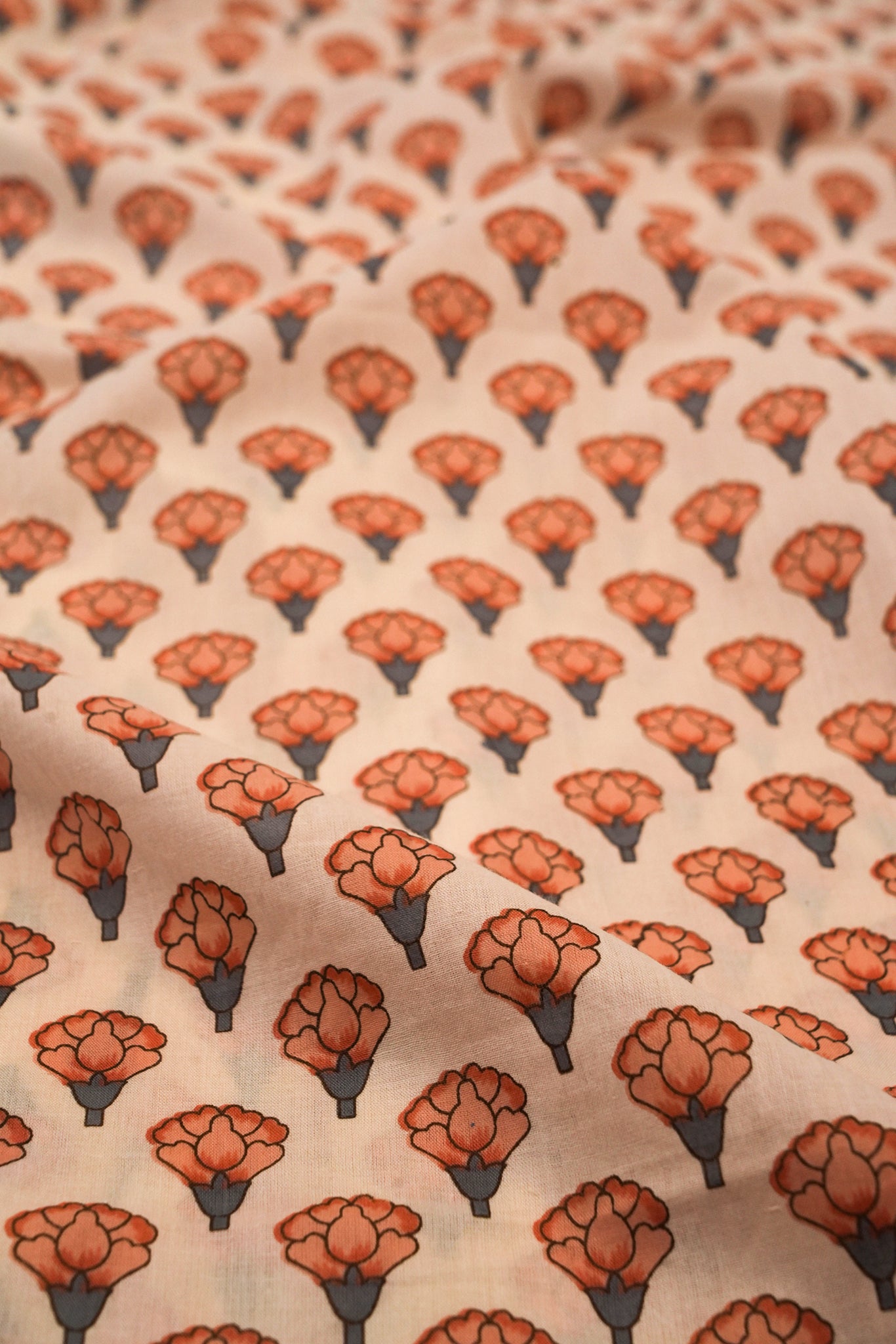 Patterned fabric with orange floral design on a beige background