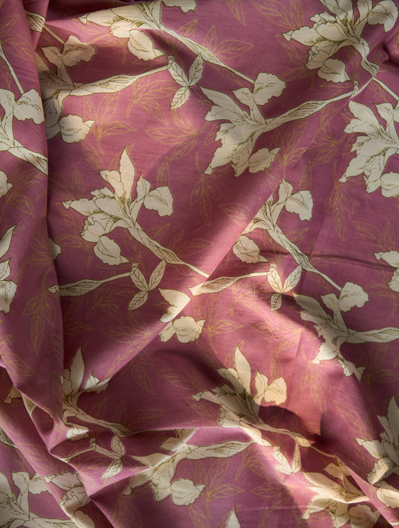 Close-up of pinkish-purple fabric with white floral pattern