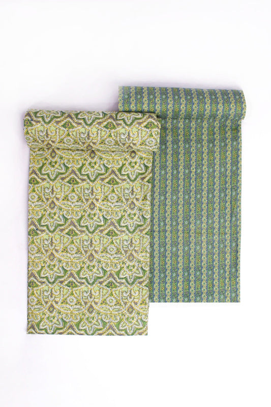 Two pieces of fabric with pastel garden patterns, one in pastel green and the other in a combination of pastel green and lavender, both with geometric designs.
