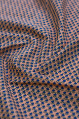 Close-up of fabric with blue and green pattern on a pink background