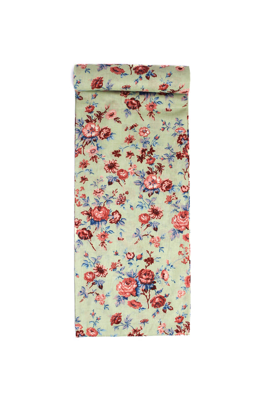 Fabric with a rustic floral pattern featuring pink, red, and blue flowers on a cream-colored background