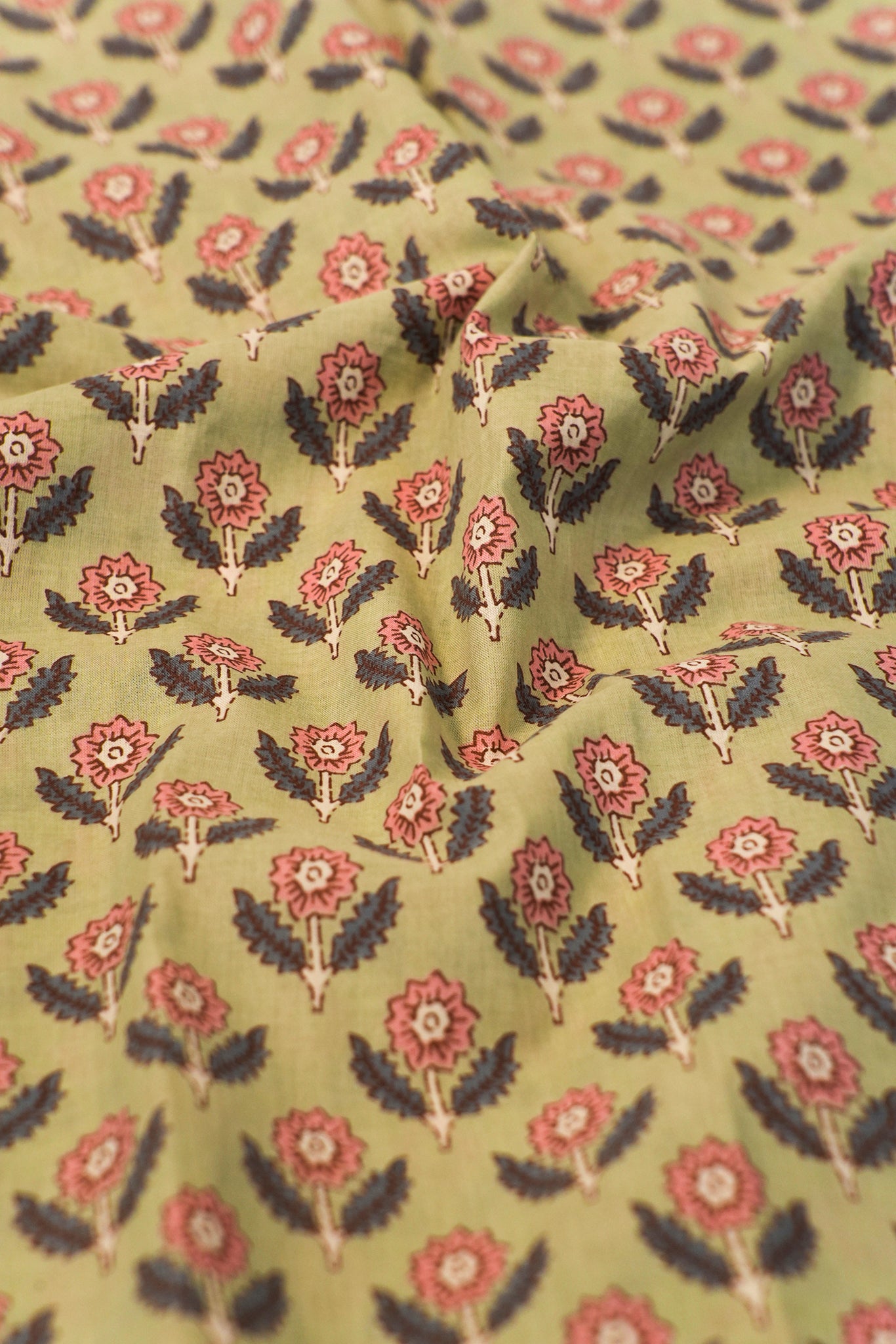 Floral patterned fabric with red and black flowers on a olive background