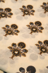 Patterned fabric with black floral designs on a beige background