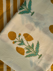 Embroidered fabric with yellow flowers and green leaves on a white background