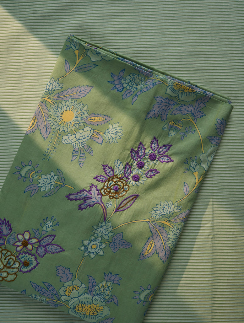 Fabric with floral embroidery on a green textured background