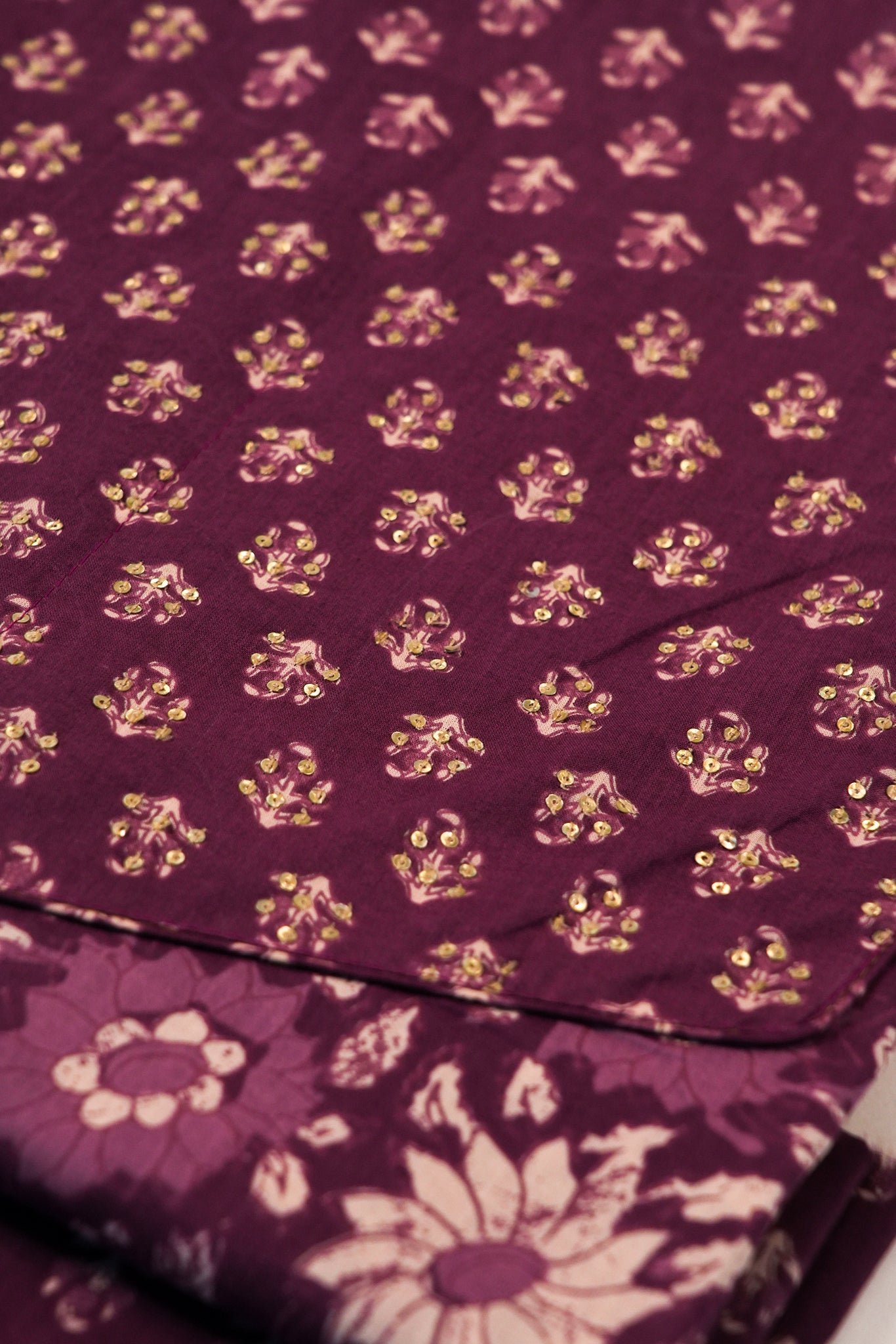 Close-up of a purple fabric with gold floral patterns