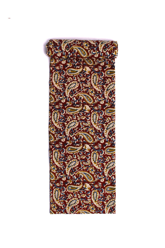 Fabric featuring a maroon scroll pattern with paisleys and floral elements on a cream background.