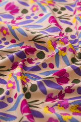 Close-up of floral patterned fabric with pink, purple, and yellow colors.