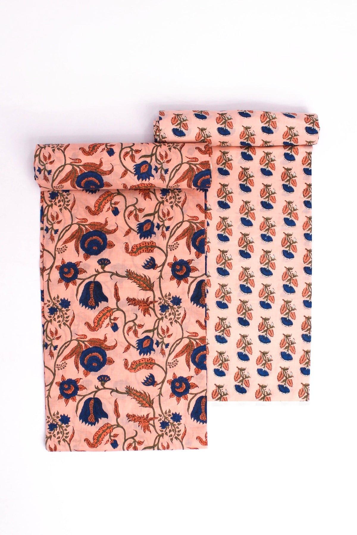 Two pieces of fabric with floral patterns, one featuring a larger floral design on a peach background and the other with a smaller floral design on a darker background.