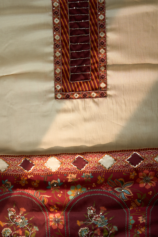 Close-up of embroidered fabric with floral patterns on a Maroon background