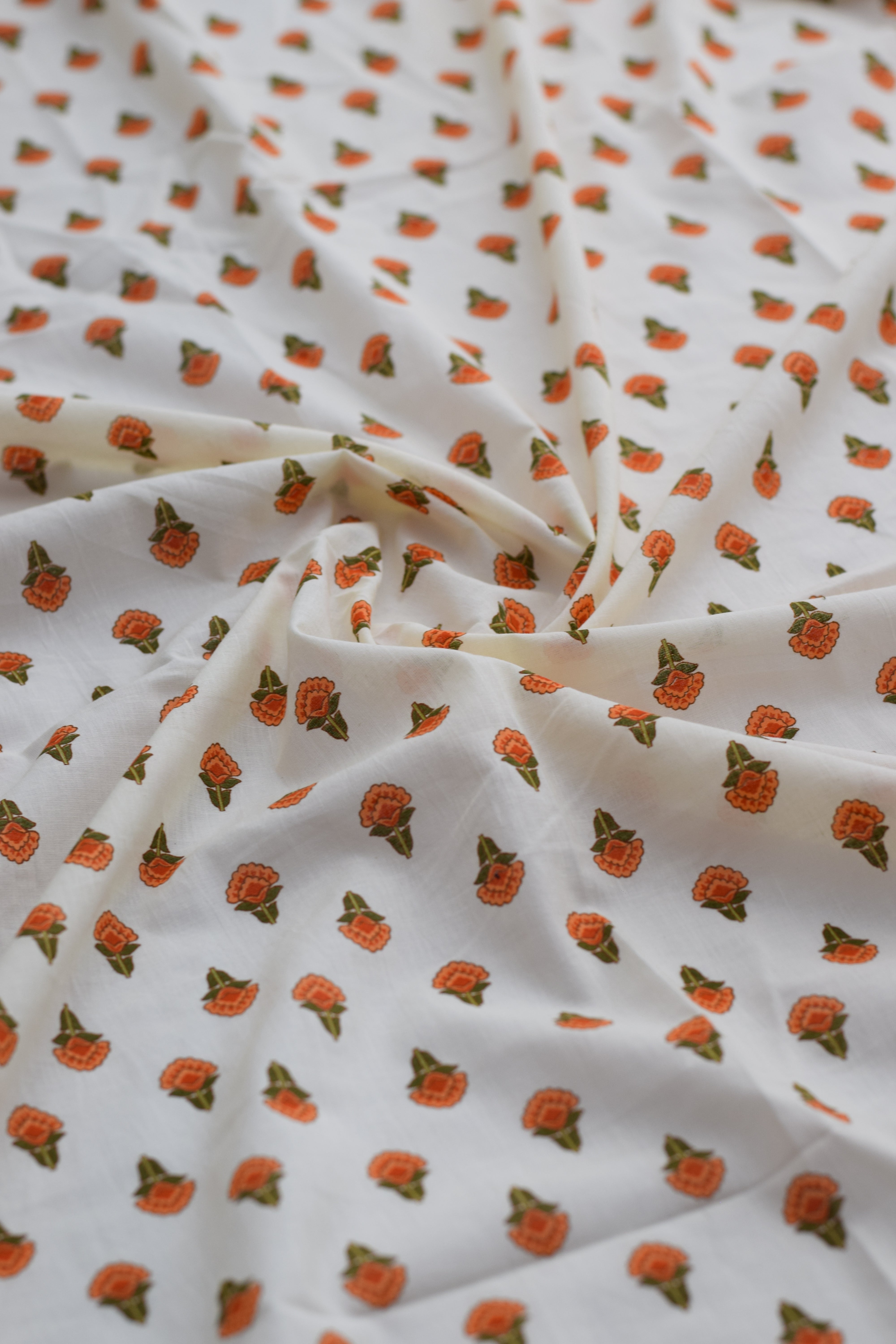 Fabric with small orange floral pattern on white background