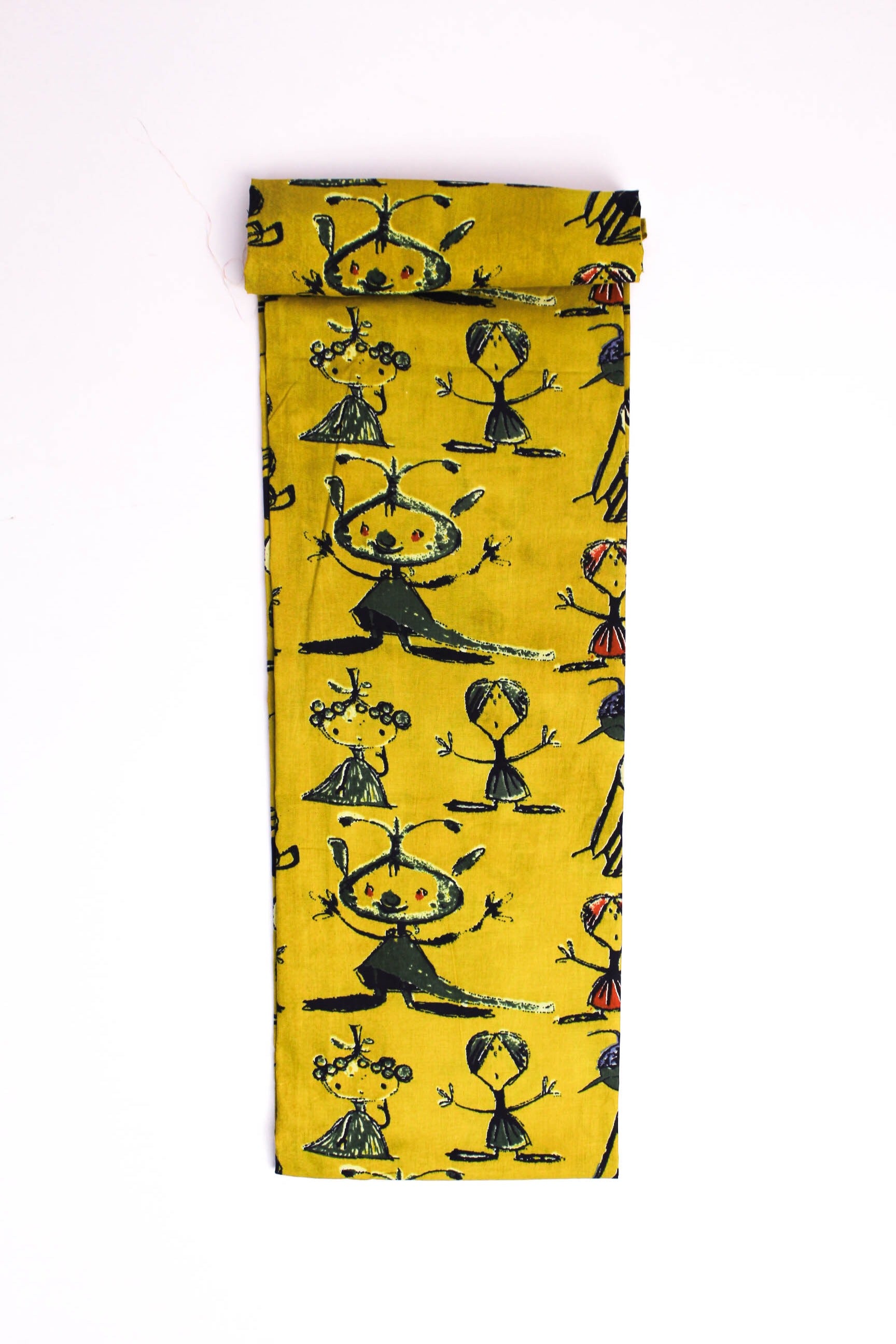 Mustard-yellow fabric with abstract tribal figures printed in red, green, and blue colors