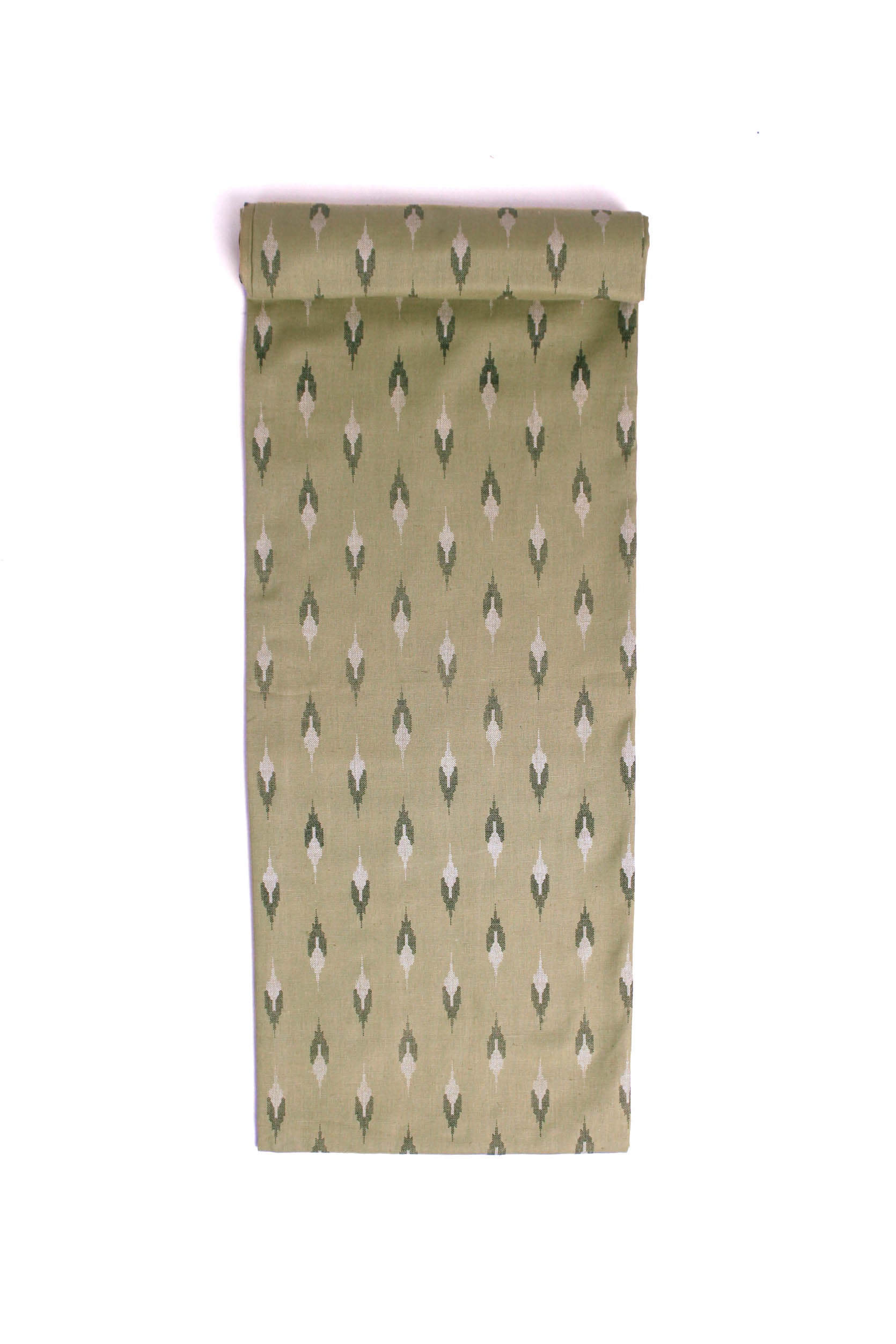 Fabric with a subtle sage green base featuring soft ikat-style motifs in black and off-white.