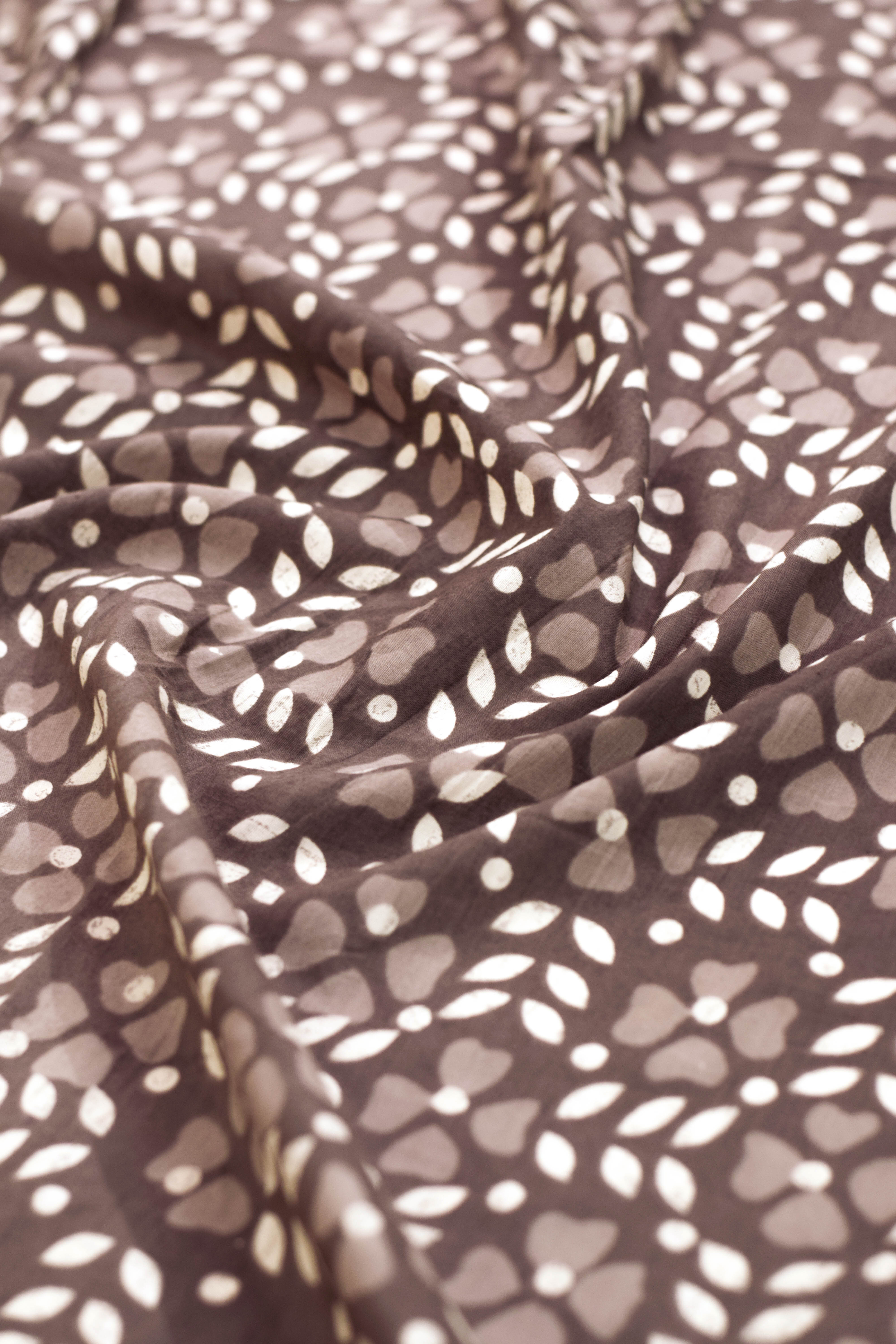 Close-up of fabric with leaf pattern in brown and white.