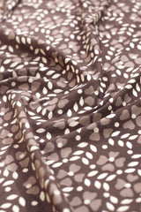 Close-up of fabric with leaf pattern in brown and white.