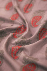 Close-up of paisley patterned fabric in red and green on a light background.