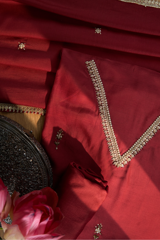 Close-up of a Maroon fabric with gold embroidery 
