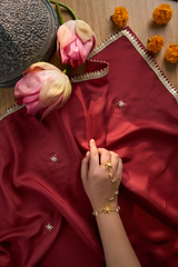 Maroon fabric with floral embroidery.