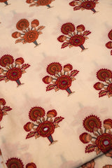 Patterned fabric with red floral designs on a beige background