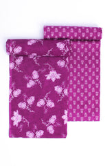 A two-piece suit set with one piece displaying a purple floral pattern on a lighter purple background and the other piece with a small, geometric purple pattern.