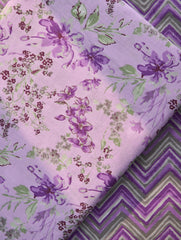 Two pieces of purple fabric with floral and zigzag patterns.