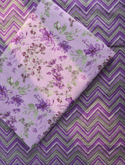 Floral fabric with purple and green pattern on a zigzag background
