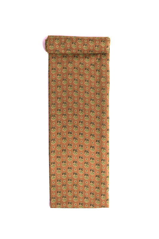 A fabric with a cheerful ochre base sprinkled with tiny teal floral motifs.