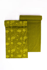 Two pieces of fabric with a floral pattern in a mehendi green color, laid flat.