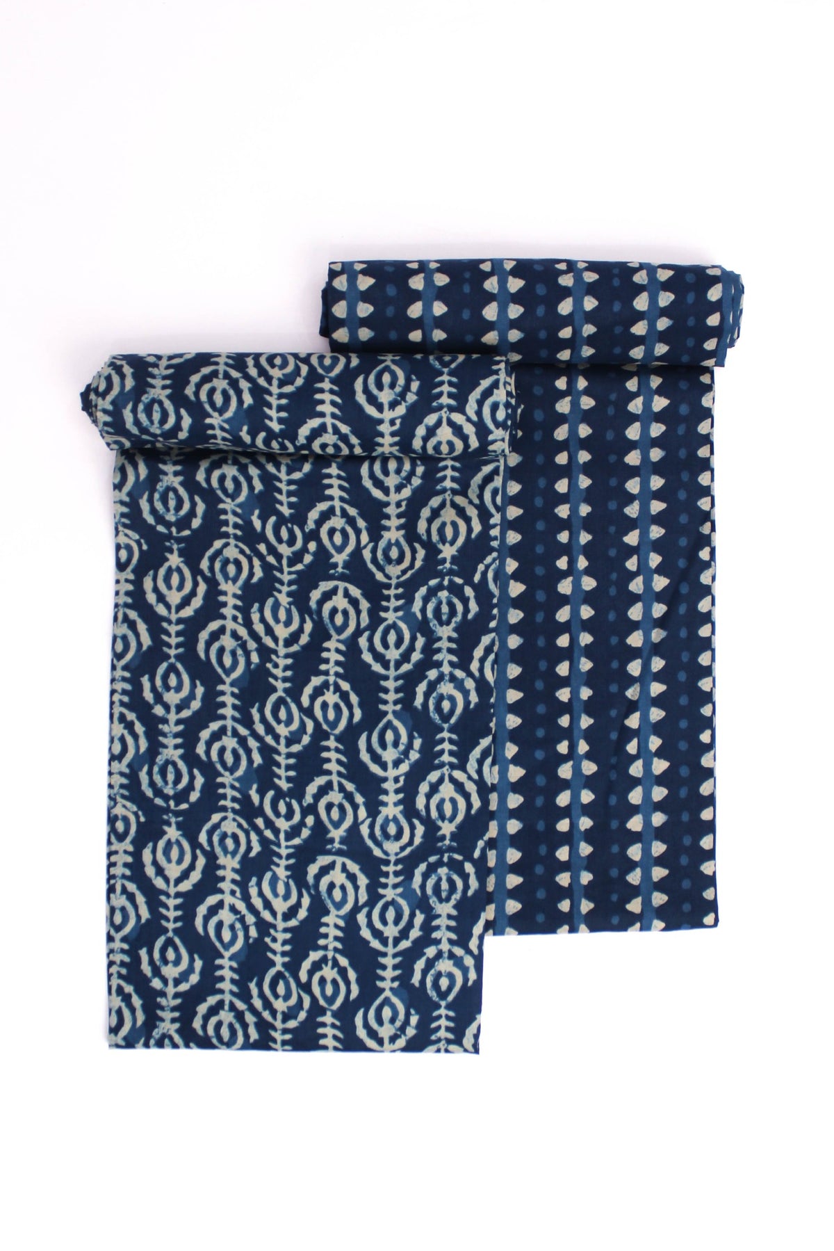 Two pieces of fabric with a midnight blue base and abstract vine and leaf-inspired motifs in yellow and beige.