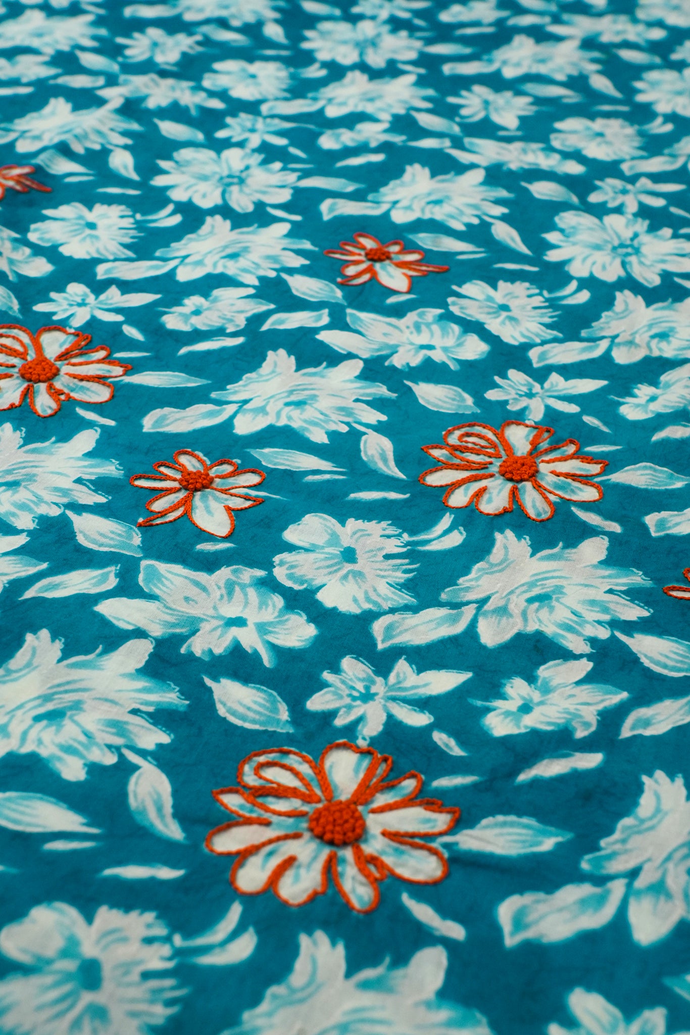 Floral pattern with white flowers and orange centers on a blue background