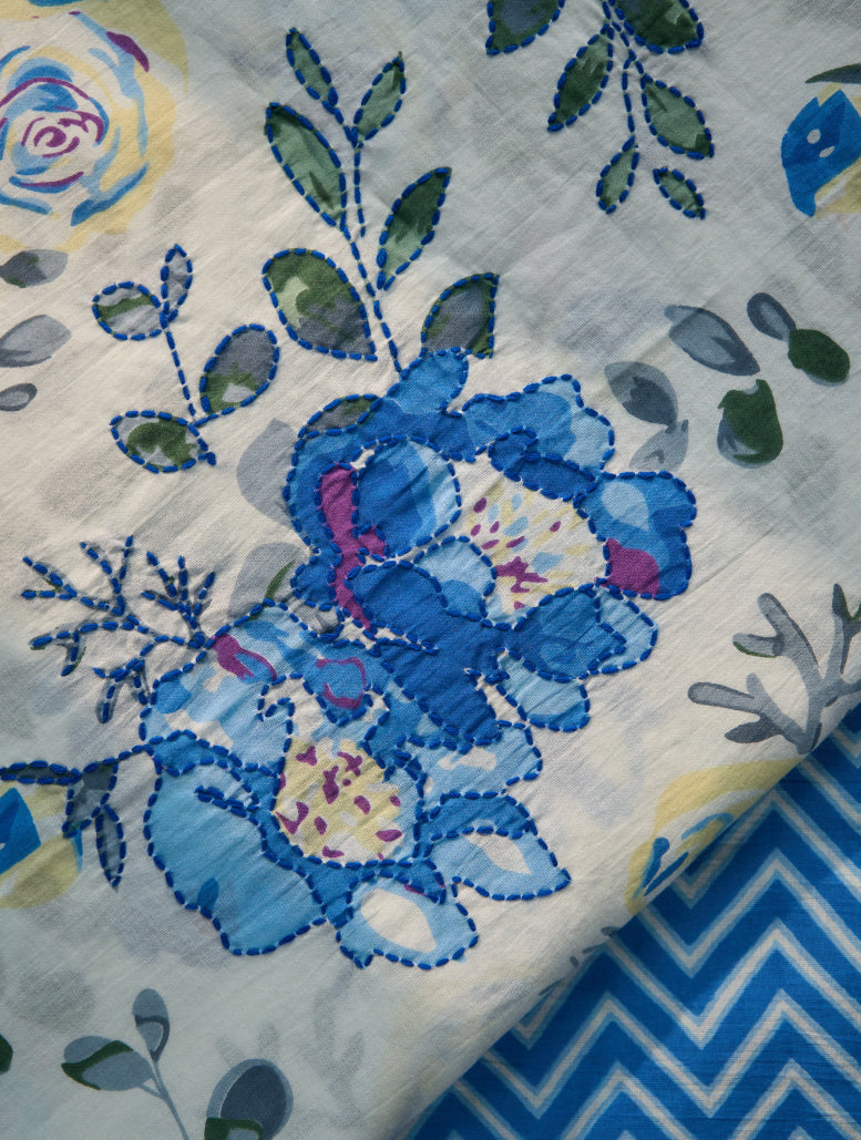 Embroidered blue teddy bear on a floral and zigzag patterned fabric
