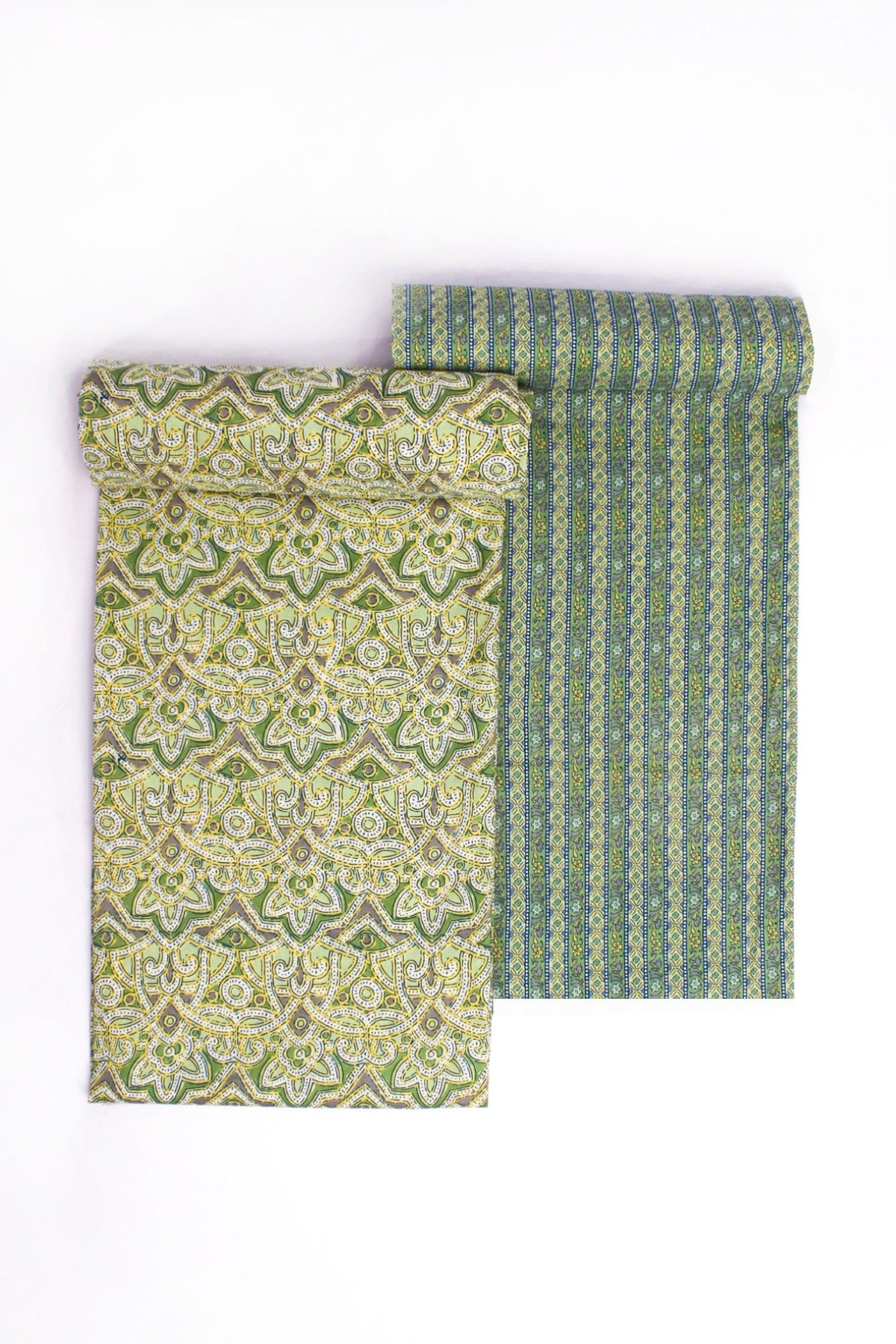 Two pieces of fabric with pastel garden patterns, one in pastel green and the other in a combination of pastel green and lavender, both with geometric designs.