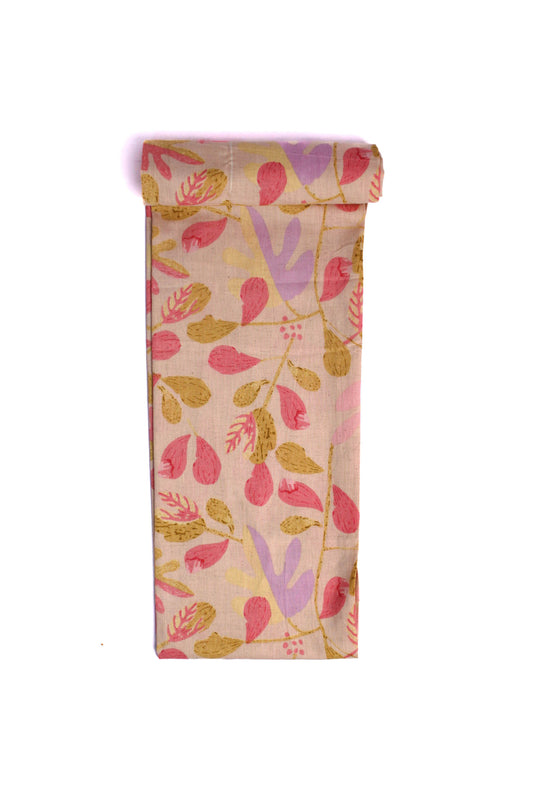 Fabric with an off-white base covered in an abstract print of pastel pink, purple, and beige leaves.