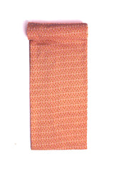 Fabric with a peach color background and orange and white dotted pattern.