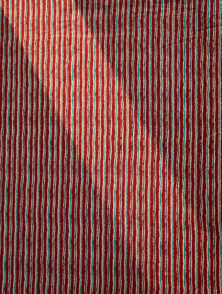 Close-up of red fabric with thin multicolored stripes