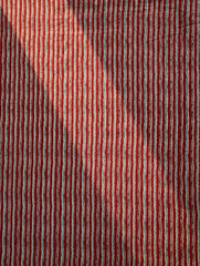 Close-up of red fabric with thin multicolored stripes
