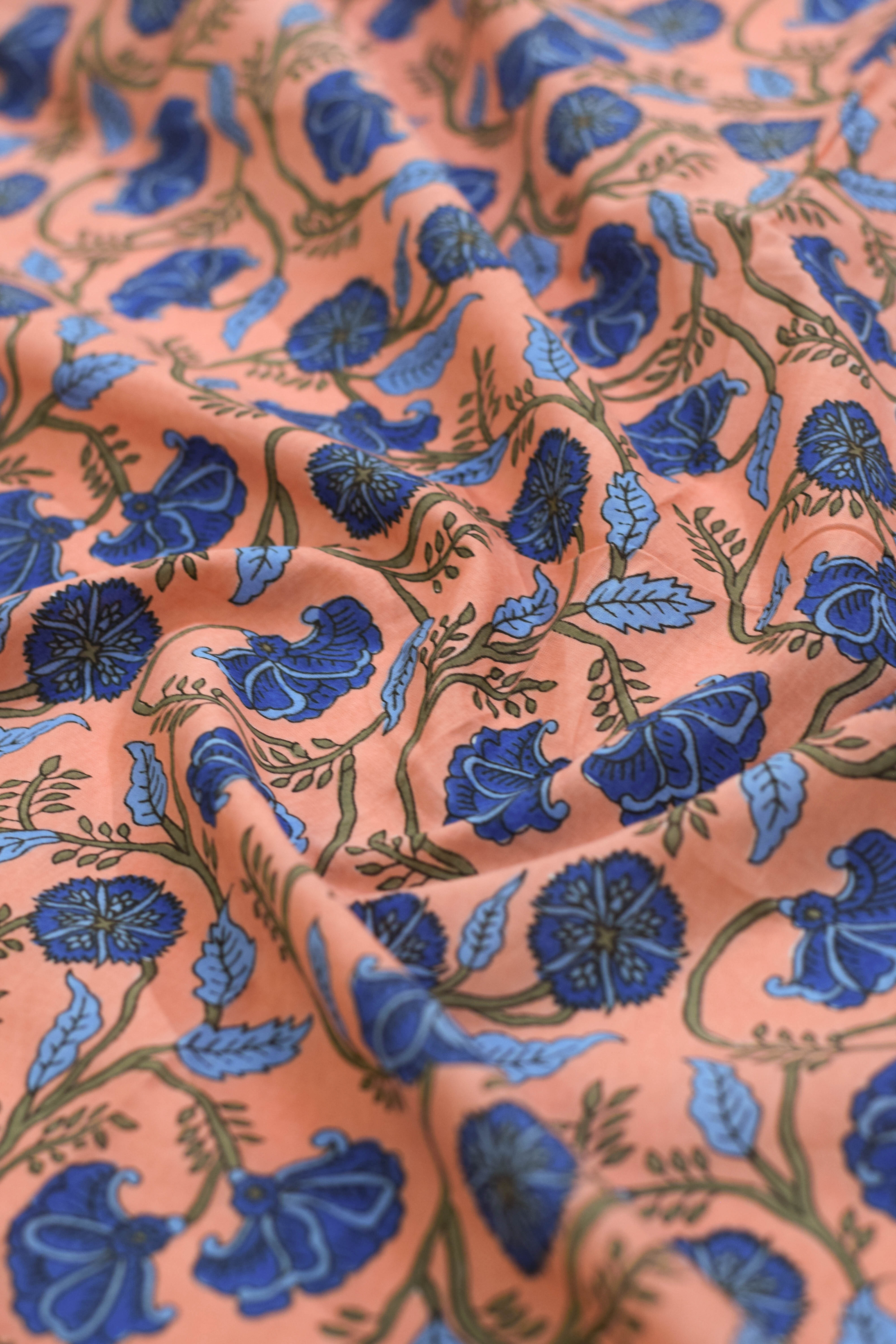Close-up of fabric with blue floral pattern on a pink background