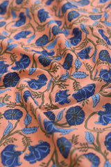 Close-up of fabric with blue floral pattern on a pink background