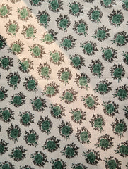 Patterned fabric with green floral design on a beige background