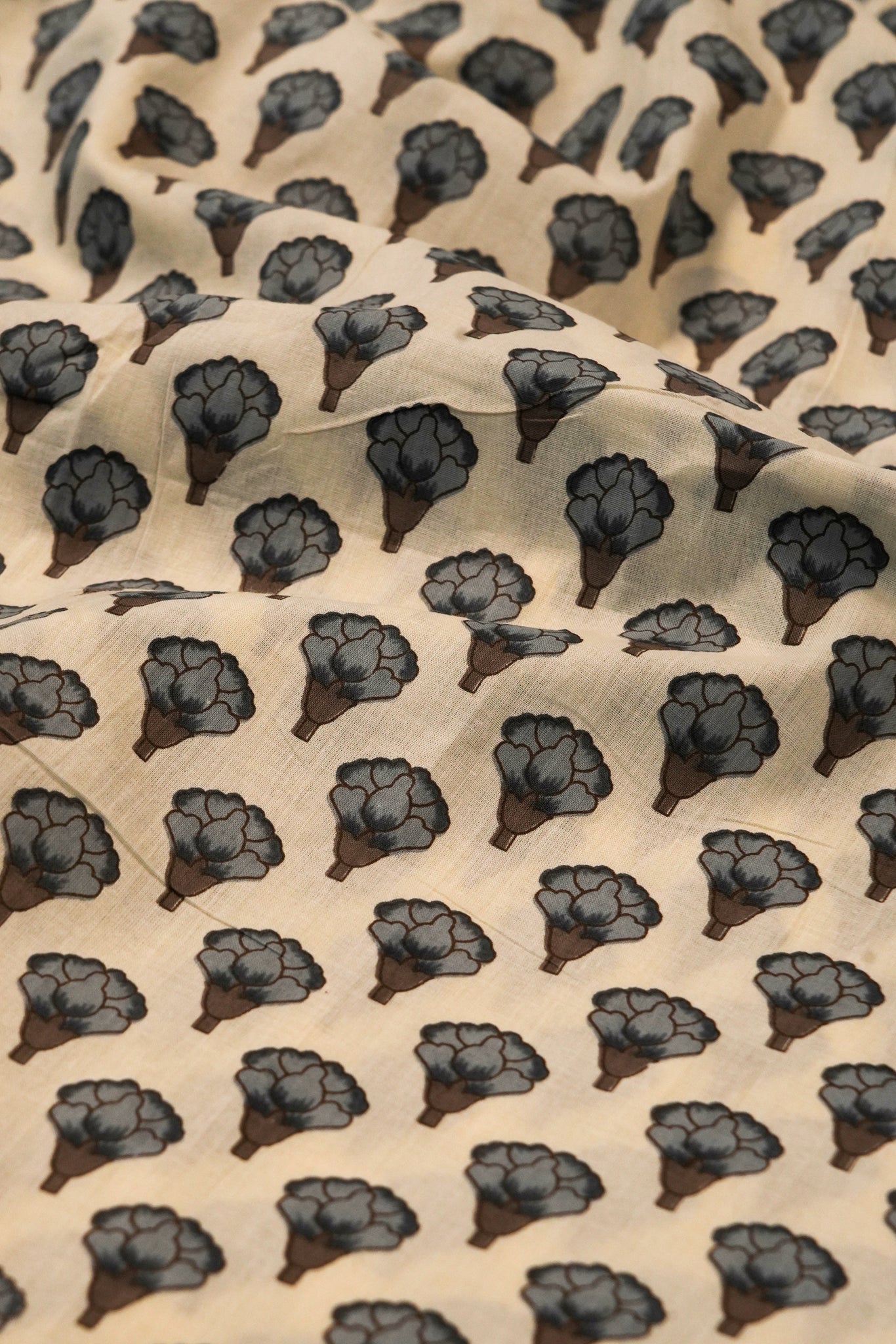 Patterned fabric with black floral shapes on a beige background