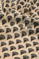 Patterned fabric with black floral shapes on a beige background