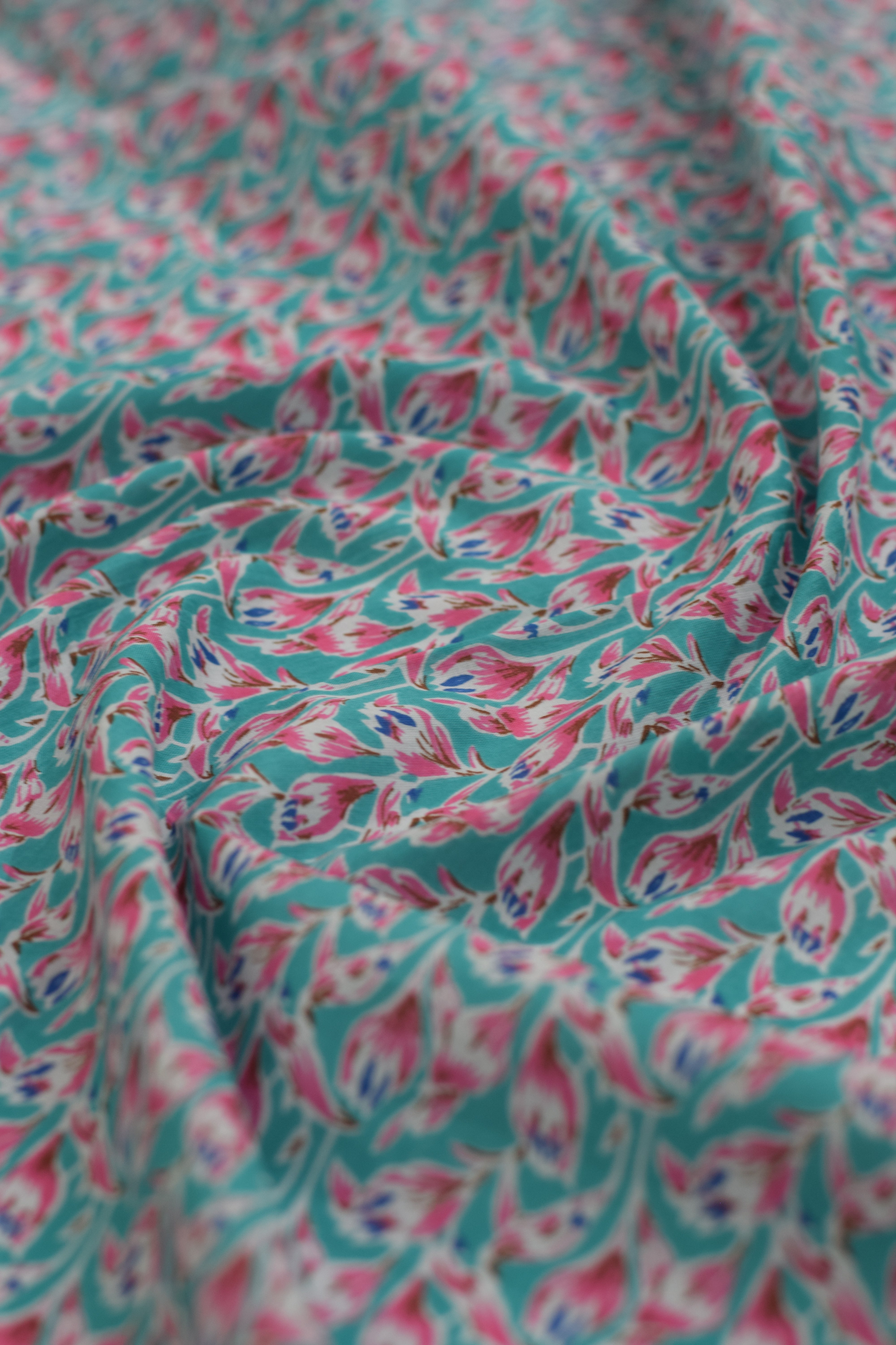 Close-up of floral patterned fabric in pink and teal.