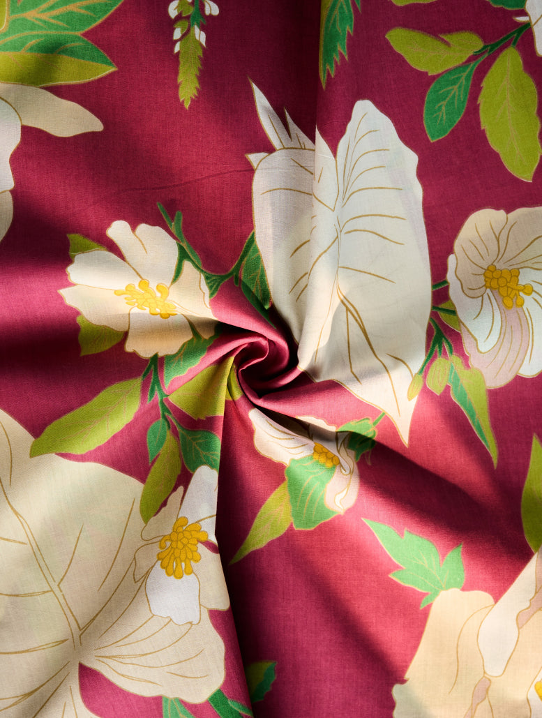 Floral fabric with white flowers and green leaves on a red background