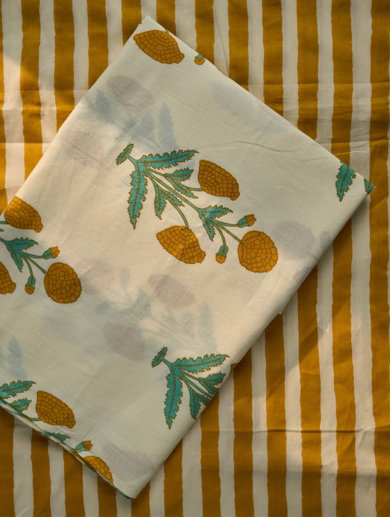 White fabric with green and orange leaf patterns on a striped background